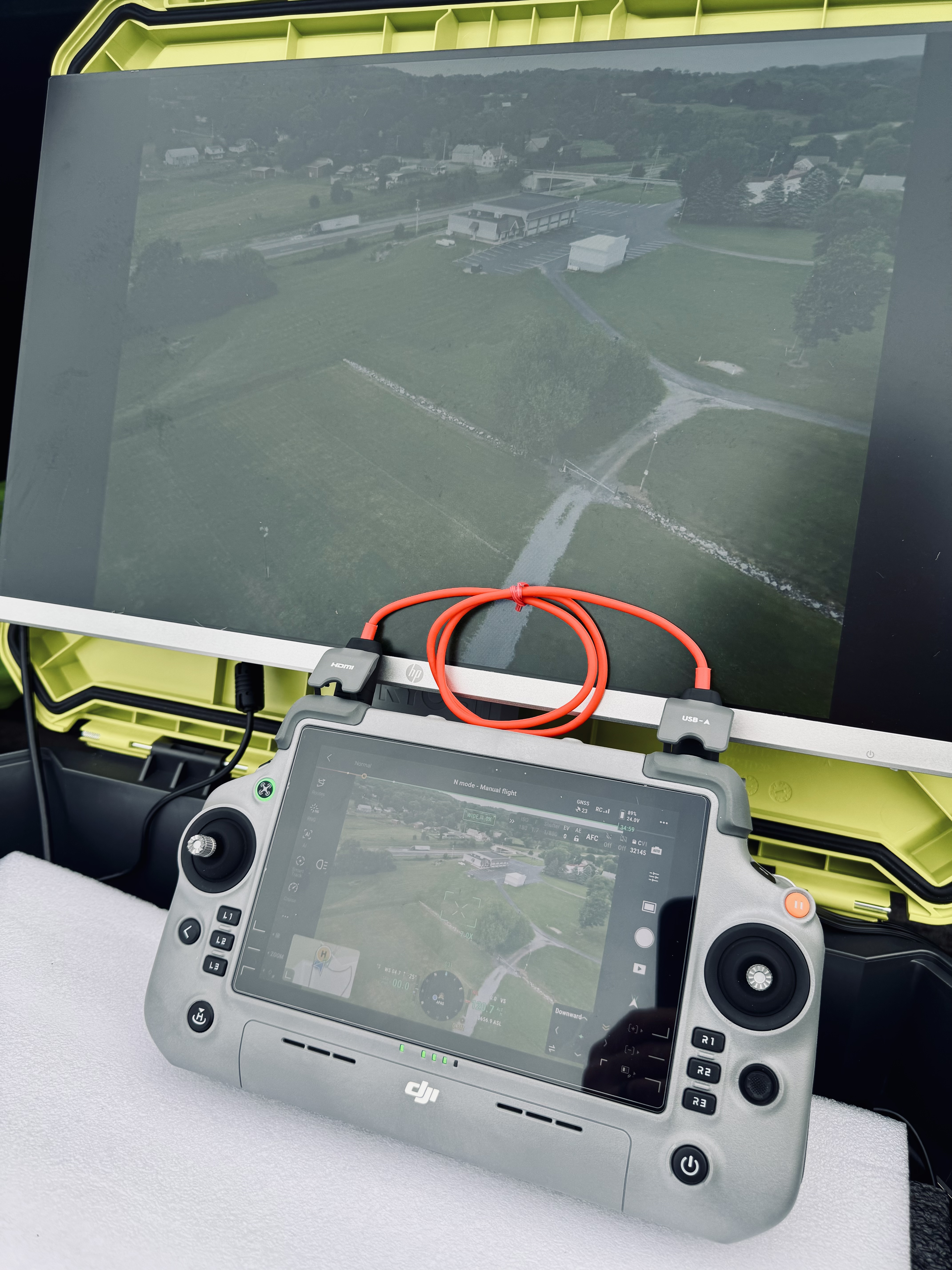 DJI RC Pro controller and ground station monitor showing live aerial feed during a search operation